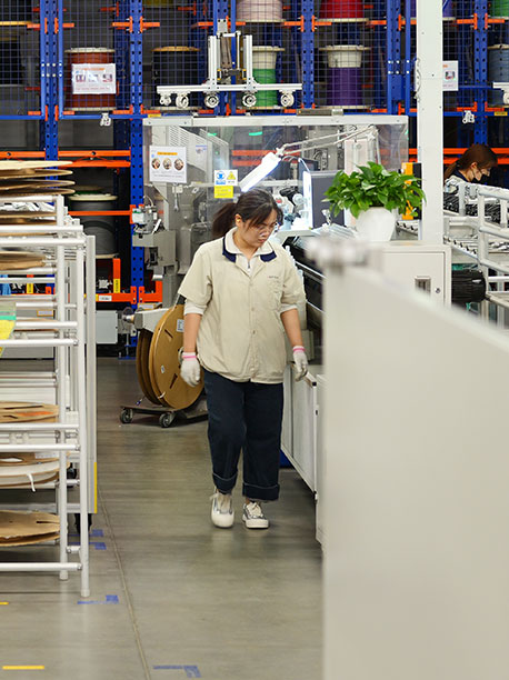 Manufacturing plant employee and wires in the background